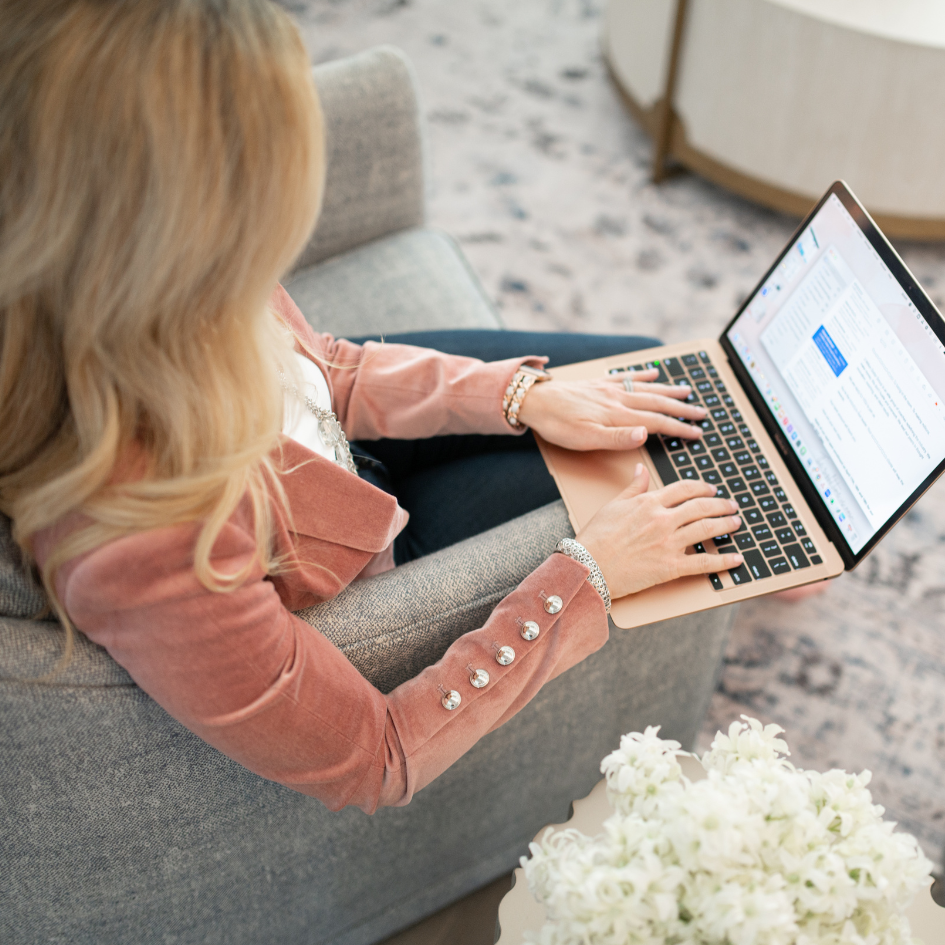 Lynda McDonell reviewing financial work on her laptop from an armchair