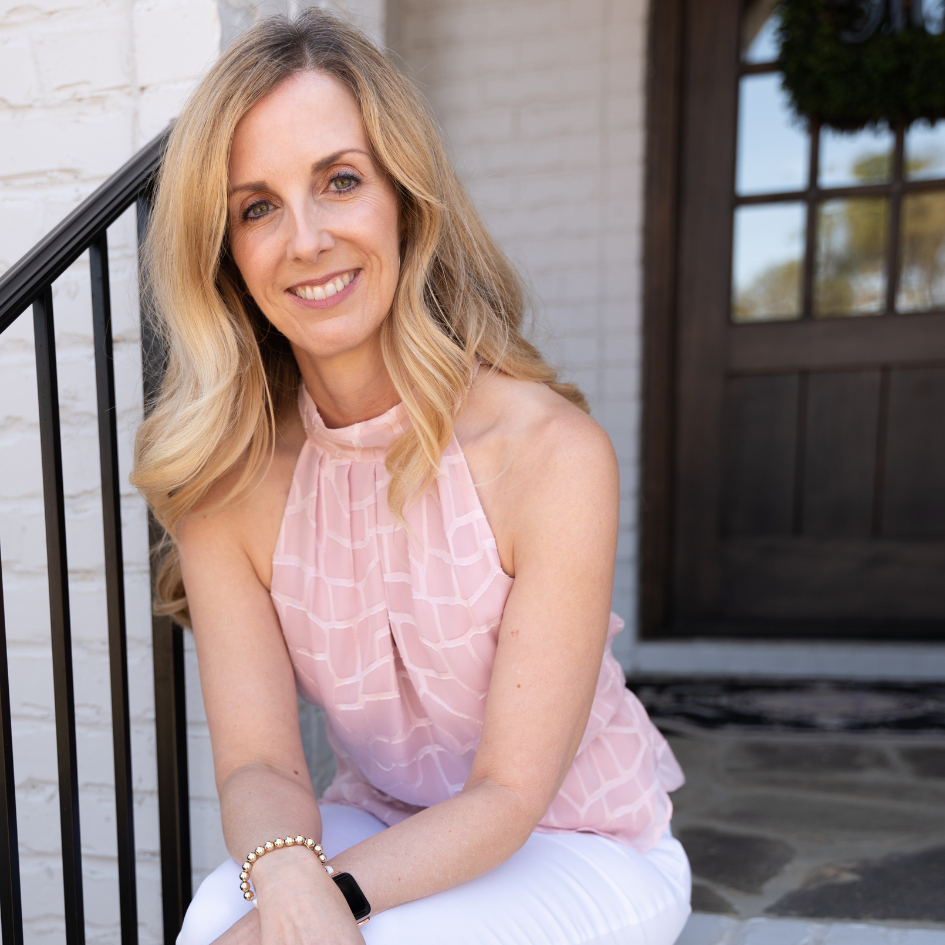 Lynda McDonell seated on the steps outside, smiling